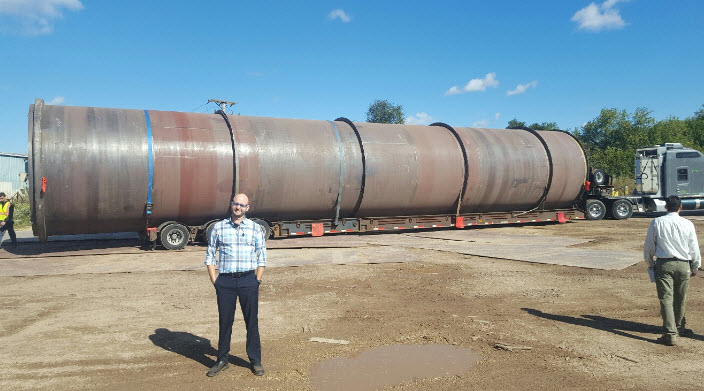 Employee in front of large rolled plate